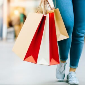 A woman walking in a mall with multiple shopping bags in her hands