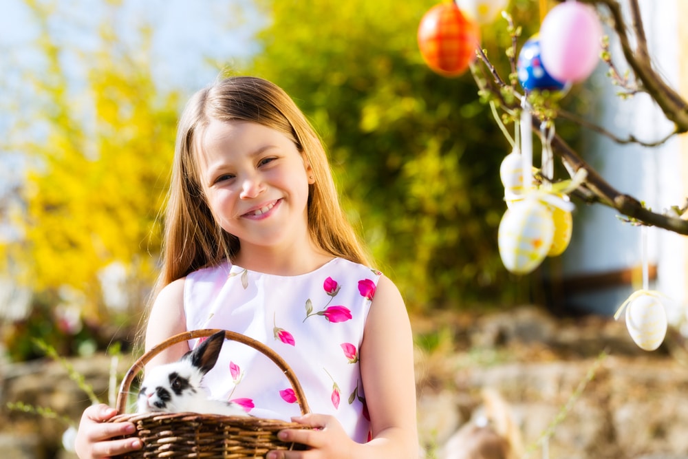 a lovely little girl holding a basket with an Easter bunny